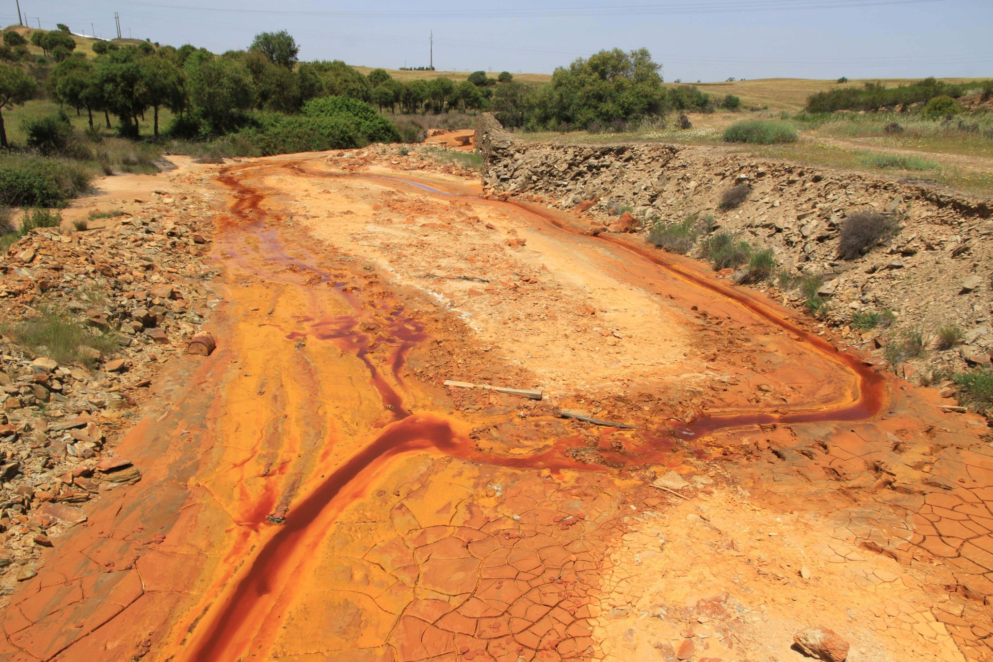 Partial sight of a strectch of the Ribeira de Águas Fortes, where MAD damage is evidente. The elevated amounts of iron which, despite being insoluble remains inside the sollution with high concentraion in colloidal form, give the water its dark red colour.